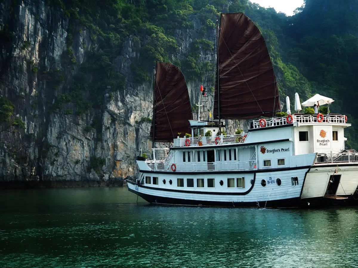 Dragon's Pearl cruise junk under full sail on Bai Tu Long Bay